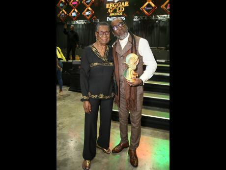 Orville Hall, founder of Dance Xpressionz, celebrates his Reggae Gold Award with his mother, Laurel Hall, last Friday at the National Indoor Sports Centre. 