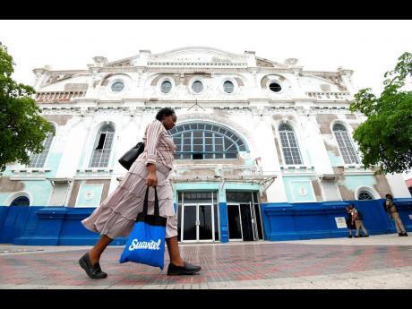 A lady is seen walking past the Ward Theatre at North Parade in downtown Kingston.