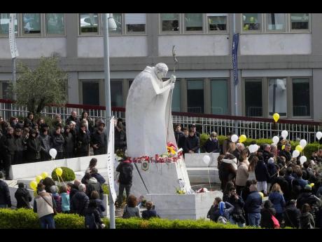 Faithful pray for Pope Francis outside the Agostino Gemelli polyclinic in Rome on Sunday, March 16.