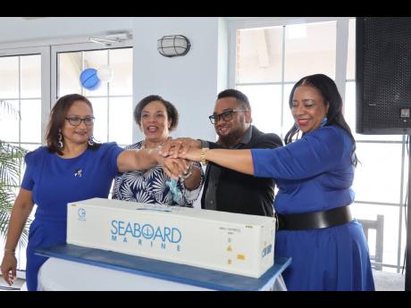 Members of the Seaboard Jamaica team cutting a cake replicating a Seaboard Marine refrigerated container at a recent anniversary event. From left: Traffic Manager Zahra Masters; Chief Executive Officer Corah Ann Robertson-Sylvester; Operations Manager Shaw