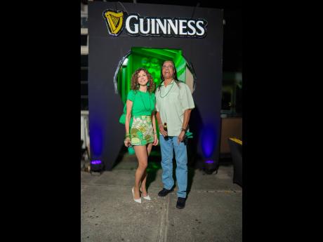 Susanna Gomez rocks vibrant hues of green, standing next to DJ Archie.
