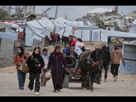 Displaced Palestinians, carrying their belongings, move away from the areas where the Israeli army is operating after Israel’s renewed offensive in the Gaza Strip, on the outskirts of Beit Lahia yesterday.