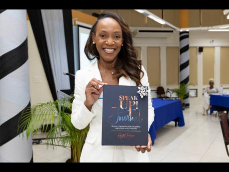 Meila McKitty Plummer, branch manager, Sagicor Life Corporate Circle branch, shows off her copy of the 'Speak Up!' journal.