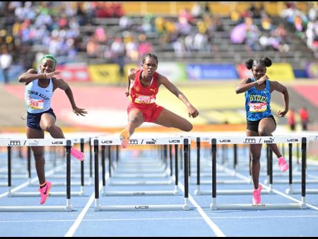 Wolmer’s Girls Tianna Marshall (centre) will have her hands full in the girls’ Class 3 100-metre hurdles.