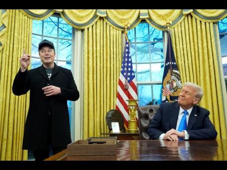 President Donald Trump listens as Elon Musk speaks in the Oval Office at the White House, in Washington, DC. 
