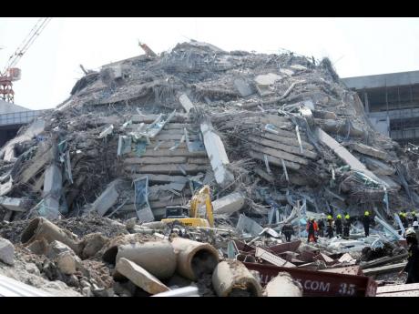 Rescuers work at the site of a high-rise building under construction that collapsed after a 7.7 magnitude earthquake in Bangkok, Thailand yesterday.
