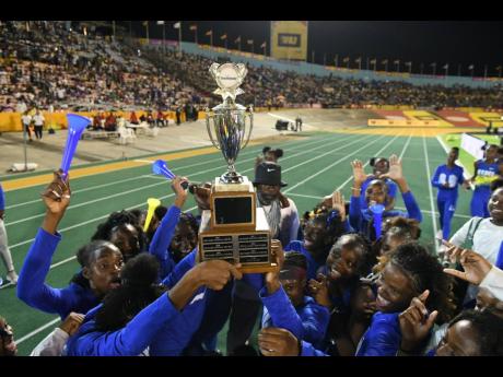 Credit: Gladstone Taylor Hydel athletes raise the Champs trophy aloft in celebration of their win inside the National Stadium yesterday.