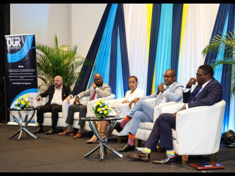 President and CEO of Jamaica Public Service, Hugh Grant (second right) makes a point while fellow panellists listen keenly. From left are: Stephen Murad, CEO of Digicel; Herman Fagan, VP of operations, National Water Commission; moderator, Kalilah Reynold 