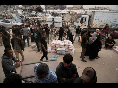 Palestinians receive bags of flour and other humanitarian aid distributed by UNRWA, the UN agency helping Palestinian refugees in Jabaliya, Gaza Strip, yesterday.