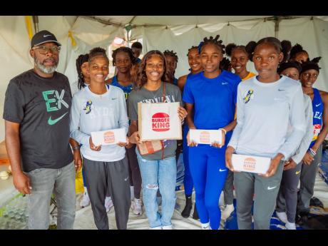 U20 gold medallist and Burger King Jamaica ambassador Alana Reid (centre) was on hand at the 2025 Issa Boys and Girls’ Athletics Championships over the weekend to hand over 80 meal vouchers to track and field athletes at her alma mater, Hydel High School