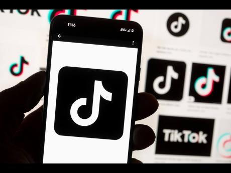 Credit: The TikTok logo is seen on a mobile phone in front of a computer screen which displays the TikTok home screen, October 14, 2022, in Boston. (AP Photo/Michael Dwyer, File)