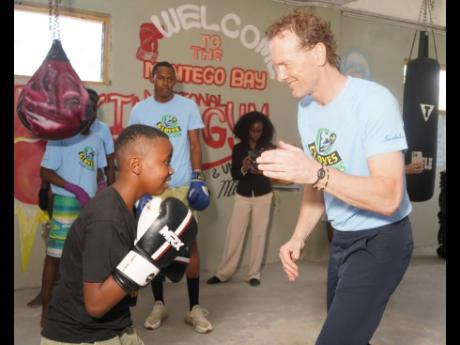 World Boxing president Boris van der Vorst (right) spars with 10 year-old Prince McIntyre, the youngest boxer in the Gloves Over Guns programme, during his visit to the Montego Bay Gym on Sunday.