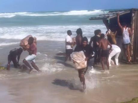 Persons seen with chicken from the container that washed ashore along the Hellshire coastline in St Catherine.