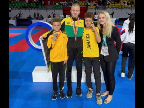 Credit: Contributed From left: Andrew, Rasandre, and Valentino Evans pose with their coach, Valentyna Zolotarova, during the recently held Central Caribbean Cup in Panama.