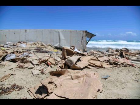 Credit: Antoine Lodge/Photographer Boxes litter the location where a container filled with chicken washed ashore along the Hellshire coastline in St Catherine last Thursday.