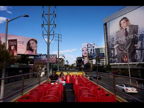 Tourists ride a double-decker bus along the Sunset Strip in Los Angeles, Friday, April 4, 2025.