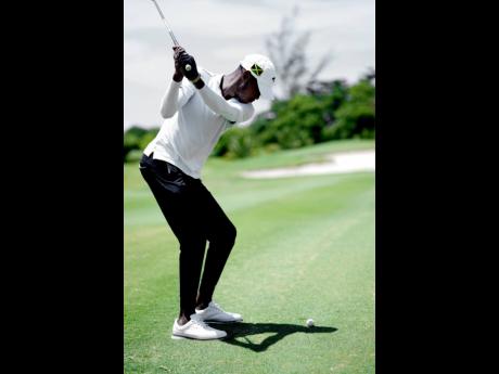 Jamaican golfer William Prendergast prepares to make a shot.