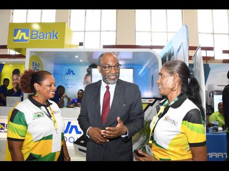 Earl Jarrett, chief executive officer of the Jamaica National Group, interacts with members of the leadership team from the Jamaica Promotions Agency (JAMPRO) – Delaine  Morgan (left), manager for exporter facilitation, and Marlene Porter, manager for in
