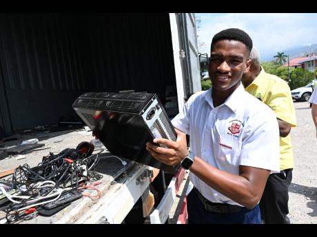In this March 2024 photo, Dirk Harrison, a lower-sixth form student at Campion College, disposes electronic devices at the launch of an Erase Your E-waste project executed in collaboration with the National Solid Waste Management Authority at the St Andrew