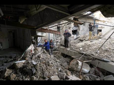 Staff inspects a building of the Al-Ahli Arab Baptist hospital after it was targeted by an Israeli army strike late Saturday following a warning issued by the army to evacuate patients, in Gaza City, Sunday, April 13.