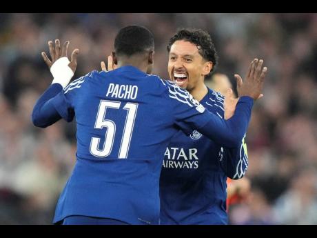 Paris Saint-Germain’s Marquinhos celebrates with teammate Willian Pacho at the end of the Champions League quarterfinal second-leg football match against Aston Villa at Villa Park in Birmingham, England, yesterday.