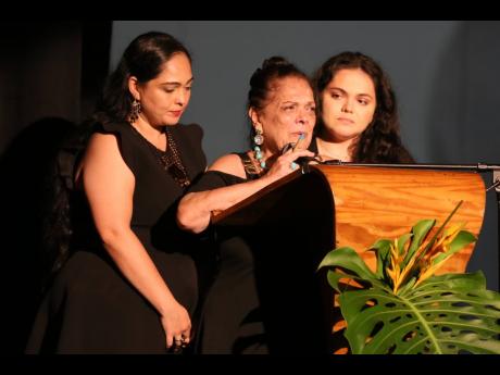 Adelina Pedroza-Zacca (centre) is supported by her daughters, Anabela (left) and Paloma, as she expresses gratitude during the Cultural Tribute and Memorial Service for her late husband, Munair Zacca.