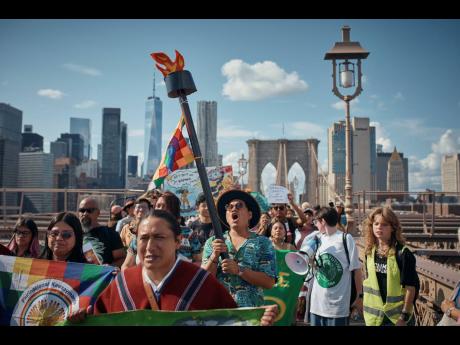 AP 
Protesters shout slogans as they cross the Brooklyn Bridge during a Youth Climate Strike march on September 20, 2024 in New York.