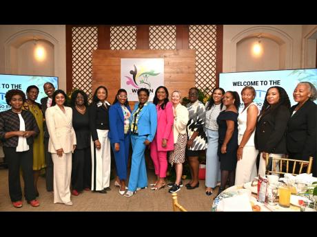 Janet Silvera (centre), founder and chair of the Women of Western Jamaica movement, with other members of the organisation during the group’s breakfast launch yesterday.