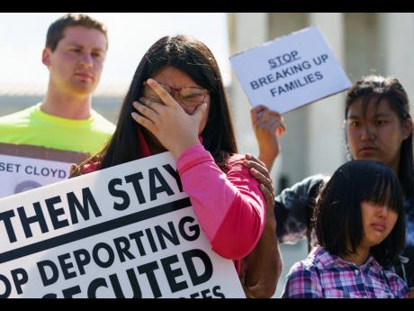 Credit: AP Caitlin Sanger of Franklin Park, New Jersey, pauses to cry outside the Supreme Court in Washington in June 2018, as she speaks about her father being detained by ICE and protests immigrant families being split up.