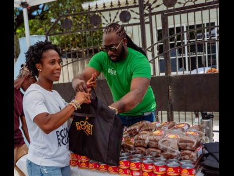 Pocket Rocket Foundation Chairwoman Shelly-Ann Fraser-Pryce (left) and Executive Director Dr Jermaine McCalpin pack bags to distribute Easter treats for families in the Waterhouse and Waterloo communities in Kingston and Ewarton, respectively. The foundati