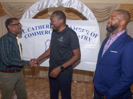 Minister without Portfolio with Responsibility for Works, Robert Morgan (centre), is greeted by President of the St Catherine Chamber of Commerce and Industry, Dennis Robothom (left), on Wednesday, at the organisation’s monthly meeting held in Spanish To