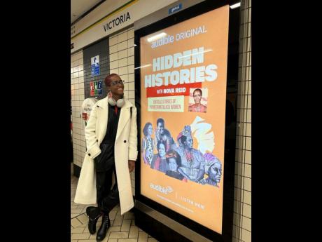 A smiling Nova Reid checks out the poster advertising her latest project, ‘Hidden Histories’ .