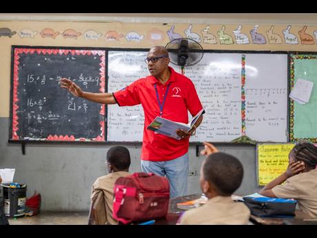 Credit: Contributed D&G Foundation volunteer Chester Grant has an interactive discussion with a grade 5 class at Seaview Gardens Primary School on Read Across Jamaica Day.
