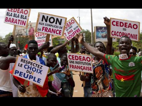 Supporters of Ibrahim Traoré protest against France and the West African regional bloc known as ECOWAS in the streets of Ouagadougou, Burkina Faso, in October 2022. 