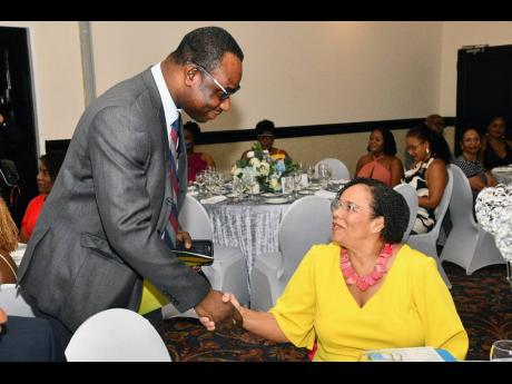 Permanent Secretary in the Ministry of Culture Gender, Entertainment and Sport, Dean-Roy Bernard, greets Chair of the Maritime Authority of Jamaica (MAJ), Corah-Ann Robertson-Sylvester, during the Women in Maritime Association Caribbean (WiMAC) 10th Annive