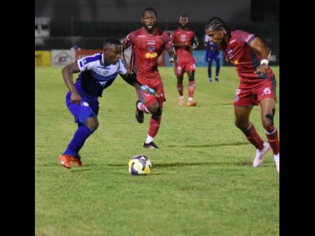 Mount Pleasant’s Franco Celestin (left) tries to outrun Montego Bay United FC’s Darnell Hospedales (centre) and Jordon Meshak Britto during their Jamaica Premier League first-leg semi-final football match at Montego Bay Sports Complex in St James on Th