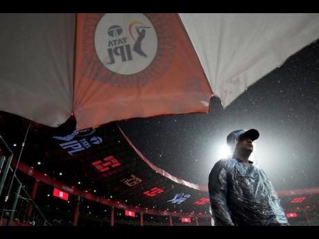 
A security person stands in the rain shortly before the scheduled start of the Indian Premier League cricket match between Kolkata Knight Riders and Royal Challengers Bengaluru at Chinnaswamy Stadium in Bengaluru, India yesterday.