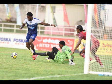 Mount Pleasant’s Raheem Edwards (left) beats Montego Bay United’s goalkeeper Davonnie Burton (centre) but failed to score during yesterday’s Jamaica Premier League semi-final match at Sabina Park.  