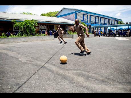 Boys from the Sir Clifford Campbell Primary School enjoying a game of football on the newly paved play area.