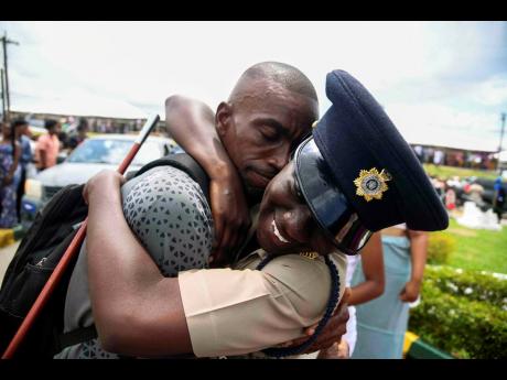 Onisha Bramwell Best JNSC intake 24-01 of the Number 6 Platoon (right) is embraced by her father, Dwight Bramwell (left), at the passing-out parade of the Jamaica National Service Corps Intake 24-01 on May 22 at Up Park Camp. 