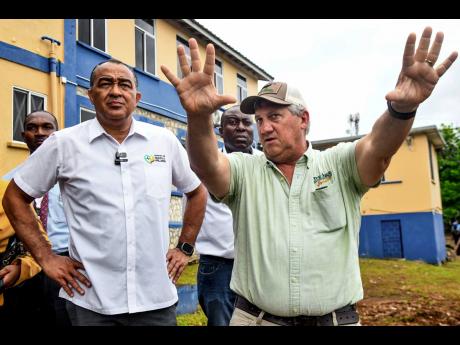 Minister of Health and Wellness of Jamaica, Dr Christopher Tufton (left) and hospital chairman, Peter McConnel (right) discuss plans including the development of an abandoned area at the Linstead Hospital in St Catherine on May 22.