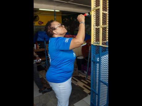 Doreen Frankson, EdgeChem Jamaica Limited founder, paints an area of the Allman Town Primary School canteen during a Labour Day initiative at the Kingston-based school. EdgeChem partnered with the Urban Development Corporation for their Labour Day project 
