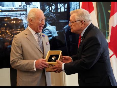 
Britain’s King Charles (left) is presented with the Key to Canada House by High Commissioner for Canada, Ralph Goodale, during a visit to Canada House to mark 100 years since it opened, at Trafalgar Square, in London, Tuesday May 20, 2025. 