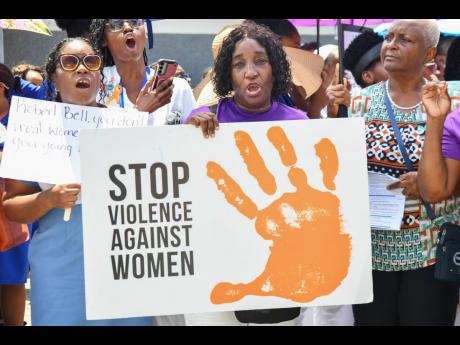 Protesters waving placards against gender-based violence during a demonstration at East Street in downtown Kingston.