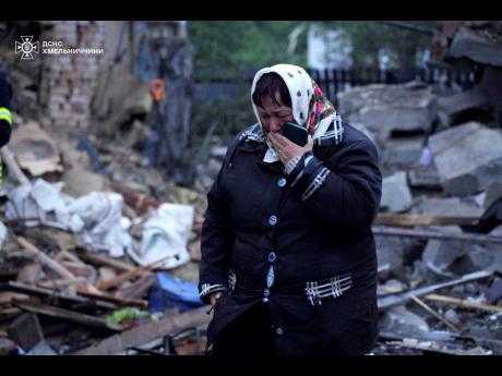 In this photo provided by the Ukrainian Emergency Service, a local resident cries standing amid the rubble of her house ruined after Russia’s air attack in Khmelnytskyi region, Ukraine, Sunday, May 25.