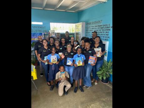 Credit: Contributed Wisynco’s Communication Ambassador and Human Resources team members engage with enthusiastic students of Freetown Primary School in Clarendon during their Read Across Jamaica Day activities.