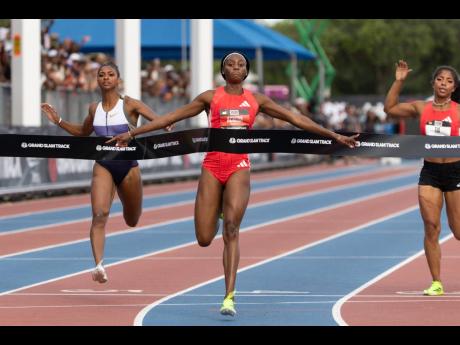 Jamaica’s Ackera Nugent (center) comes through the tape in the 100 metres at the Grand Slam Track Miami event at the Ansin Sports Complex in Miramar.