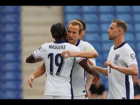 
England’s Harry Kane (centre) celebrates with Noni Madueke (left) and Jordan Henderson after scoring his side’s opening goal during a World Cup 2026 group K qualifying football match against Andorra at the RCDE Stadium in Barcelona, Spain, yesterday.