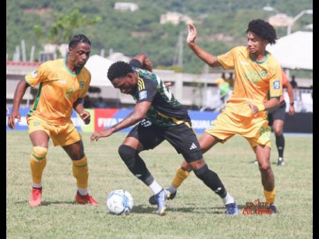 Jamaica’s Renaldo Cephas (centre) tries to evade the attentions of British Virgin Islands’ Jake Forbes (right) and Kristian Javier during their Concacaf World Cup qualifier at the A.O. Shirley Recreational Ground on Road Town on Saturday