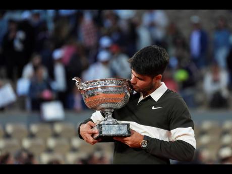 Spain’s Carlos Alcaraz celebrates with the trophy after winning the final match of the French Open tennis tournament against Italy’s Jannik Sinner at the Roland-Garros stadium in Paris, yesterday.